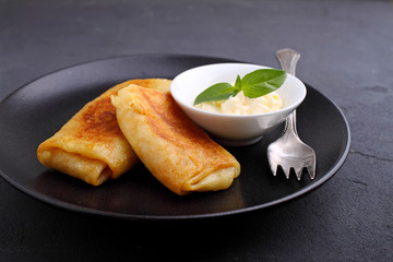 Close up of rolled pancakes with meet and sauce