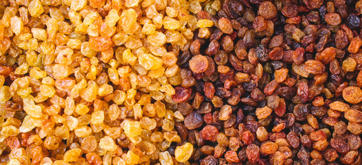 Raisins from white and black grapes forming a multi colored abstract texture background
