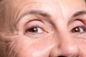 Smiling beautiful mature woman showing wrinkles and crow's feet under eyes