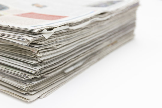 Closeup - Newspaper Stack on white table in work office 