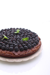 homemade chocolate cake with nuts and blackberry on white background