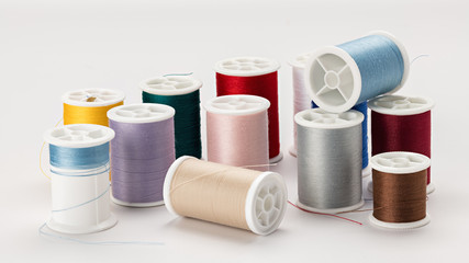 Many different colors of thread spools that have been used