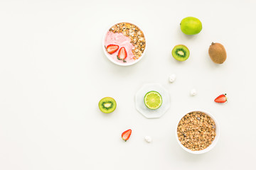 Healthy breakfast with yogurt, muesli, fruits, strawberry on grey background, flat lay, top view