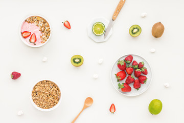 Healthy breakfast with yogurt, muesli, fruits, strawberry on grey background, flat lay, top view