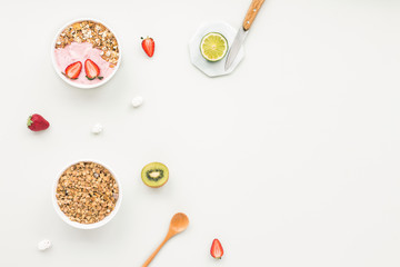 Healthy breakfast with yogurt, muesli, fruits, strawberry on grey background, flat lay, top view