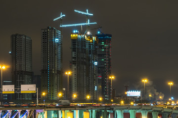 Cranes working day and night on construction of the housing estate in former industrial zone.