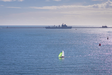 Sail boat in Plymouth Sound with Warship behind