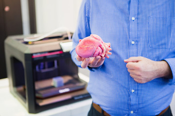 The engineer demonstrates the heart printed on a 3d printer