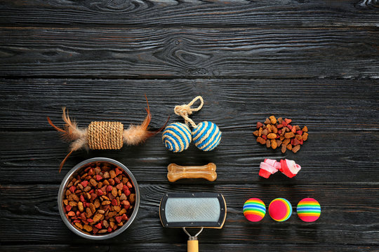 Cat's accessories and food on wooden background