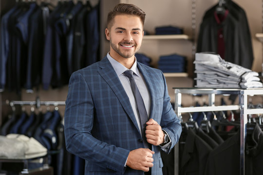 Handsome young man wearing suit in shop
