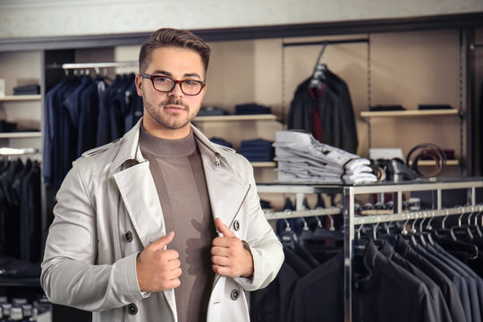 Young man in stylish coat at menswear store