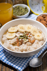 oatmeal with banana, honey and nuts, vertical closeup