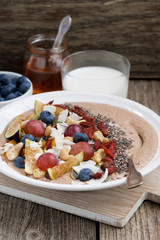 oatmeal with fresh fruit, nuts and chia for breakfast, vertical