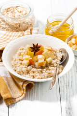 plate of oatmeal with apples and spices, vertical
