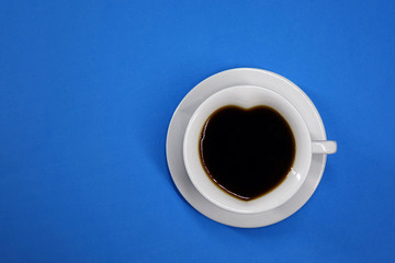coffee on a colored background top view, white Cup in the shape of a heart