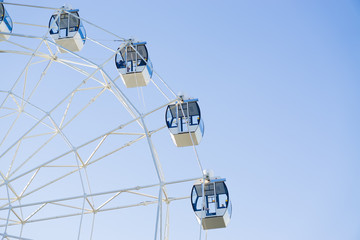 Ferris wheel on blue sky background with copy space