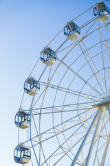 Fototapeta premium Ferris wheel on blue background vertically
