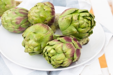 Obraz premium fresh artichokes on rustic wooden chair