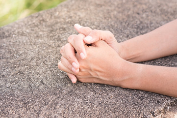 Girl claps or praying on rock table.