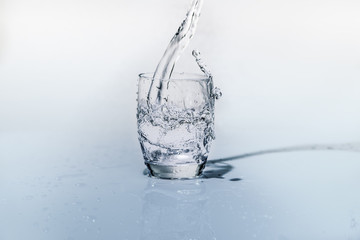 Fototapeta na wymiar bicchiere d'acqua fresca mentre viene versata dalla bottiglia