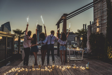 Friends partying on a rooftop - obrazy, fototapety, plakaty