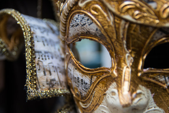 Detalle de mascara veneciana con dorados y notas musicales