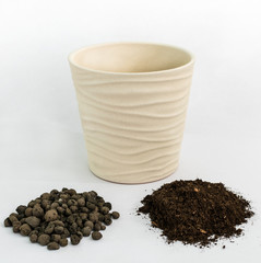 Beige pot, soil and expanded clay on a light background. Gardening at home.