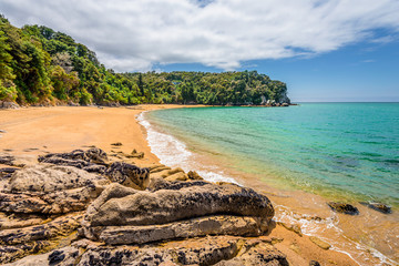 Abel Tasman National Park, New Zealand: Magical sandy beach with turquoise blue water on beautiful...