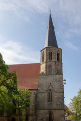 Kirchturm mit Spitzdach vor wolkenlosem blauem Himmel 
