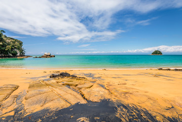 Abel Tasman National Park, New Zealand: Magical sandy beach with turquoise blue water on beautiful...
