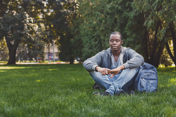 Naklejka na ściany i meble Young handsome man sitting on grass outdoors