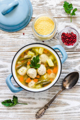 Moroccan couscous meatball soup in a pot on white rustic background. Selective focus, space for text.