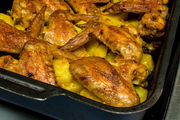 Baked chicken wings with potatoes in the oven