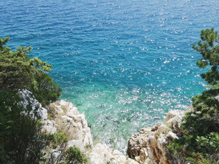 Top view of sea from cliff, summer nature, landscape with colorful sea, rock and trees. Croatia coast image.