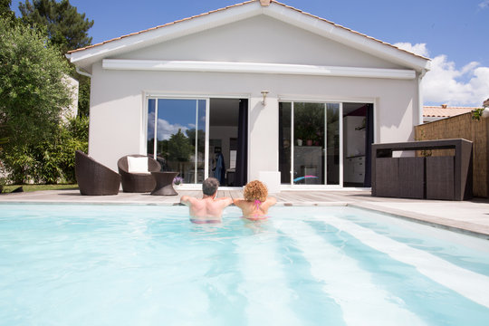 Estate Back View Of Couple In Pool Of New House