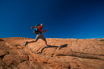 Hiker on a trail in volcanic Snow canyon State Park in Utah, USA