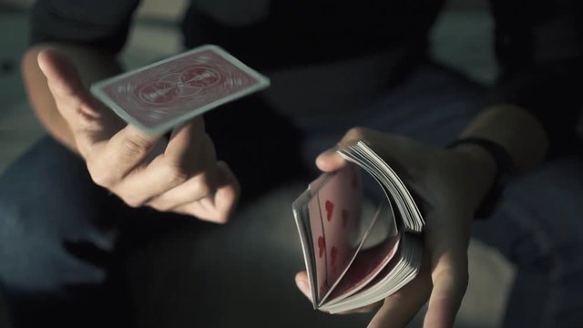 The map rotates on the finger. manipulation with a deck of cards. The magician works with a deck of cards. Slow motion