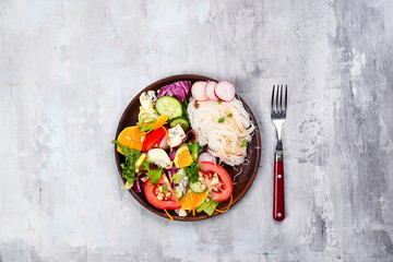 Asian spicy salad of glass noodles or funchoza with carrots and vegetables salad on stone background