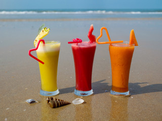 Three glasses of freshly squeezed natural juice on the ocean