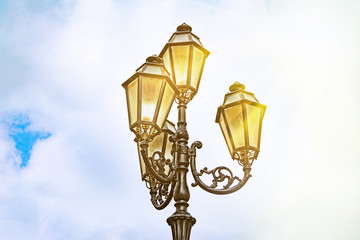 Fototapeta na wymiar Street lamp against the sky and sun at sunset, antique street lights