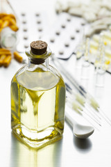 Medical syrup, various pills and injections on a metal shiny table