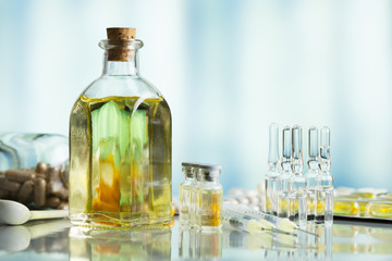 Medical syrup in a glass bottle, pills and injections on a blue background