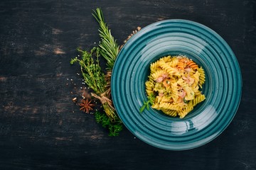 Carbonara Pasta with Bacon. On a wooden background. Italian cuisine. Top view. Copy space.