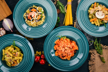A set of cooked pastes in plates. On a wooden background. Italian cuisine. Top view. Copy space.