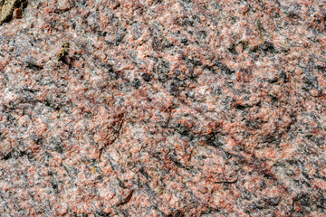 Abstract background. Close-up view of natural rought untreated grey granite texture.