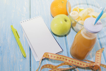 Diet, healthy and active lifestyle concept, apples, bananas, go, tape measure, juice bottle, blank Notepad top view with blank copy space.