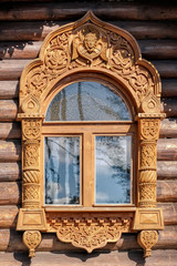 Carving decorated window on timbered house wall.