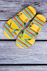 Yellow sandals on grey wood background. Flat lay, pair of flip flops on wood background.