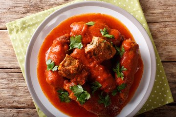 Delicious beef steak stuffed with parsley and parmesan cheese stewed in tomato sauce close-up. horizontal top view