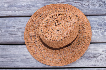 Fototapeta na wymiar Top view brown straw hat. Wooden desk surface background.